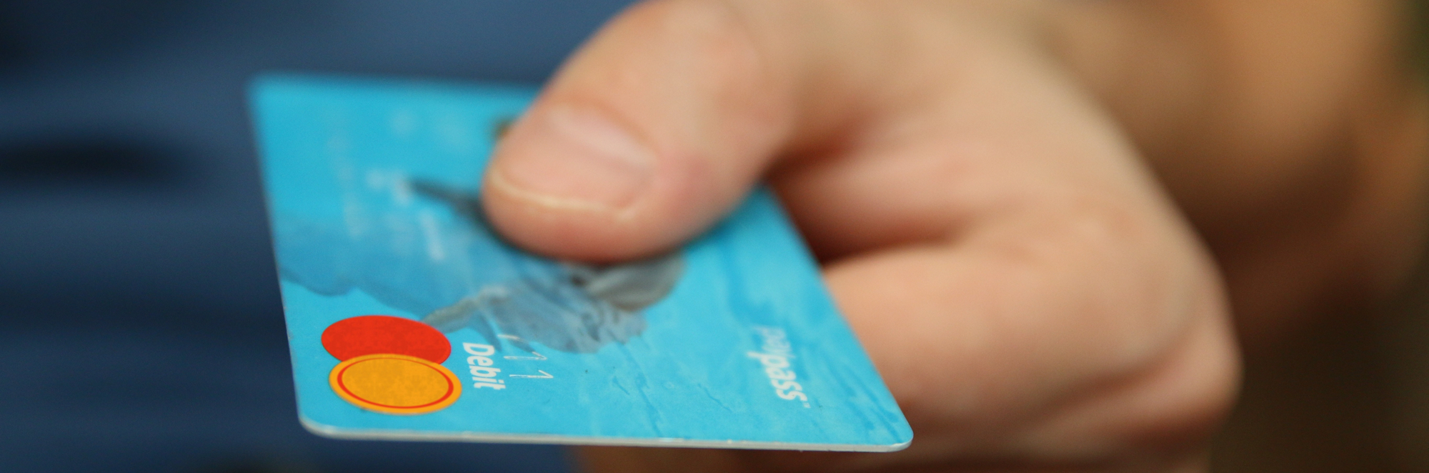 Person holding blue credit card
